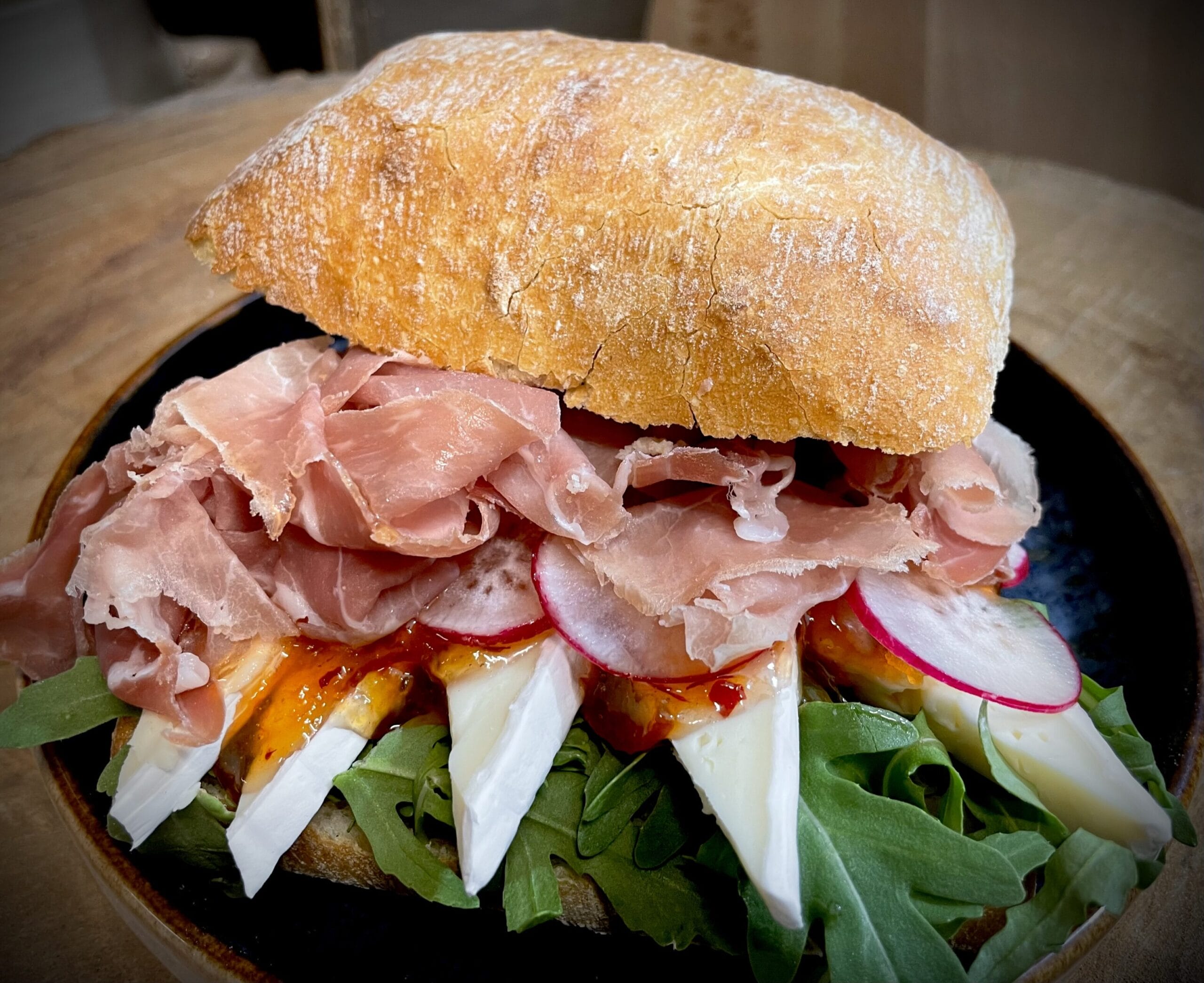 Broodje Brie met sinaasappelgelei en Italiaanse ham.